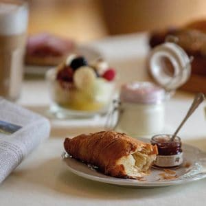 Auszug der Frühstücksauswahl im Louisa's Place am Kudamm, Croissant mit Marmelade und Obstsalat mit Joghurt